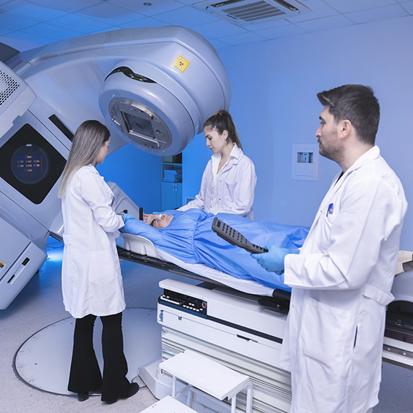 Cancer treatment in a modern medical private clinic or hospital with a linear accelerator. Professional doctors team working while the woman is undergoing radiation therapy for cancer